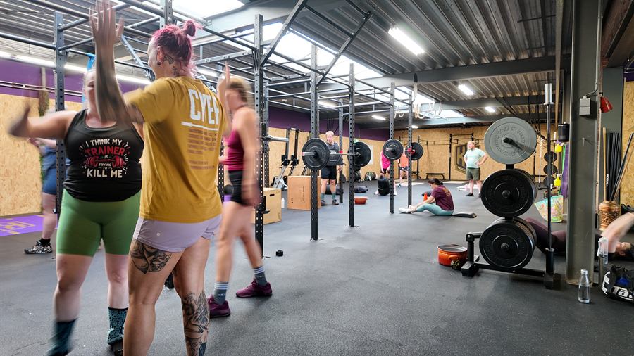Een volle zaal tijdens een les, leden trainen samen tussen de rigs
