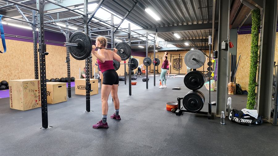 Een lid met de barbell in de front rack, klaar voor de volgende herhaling